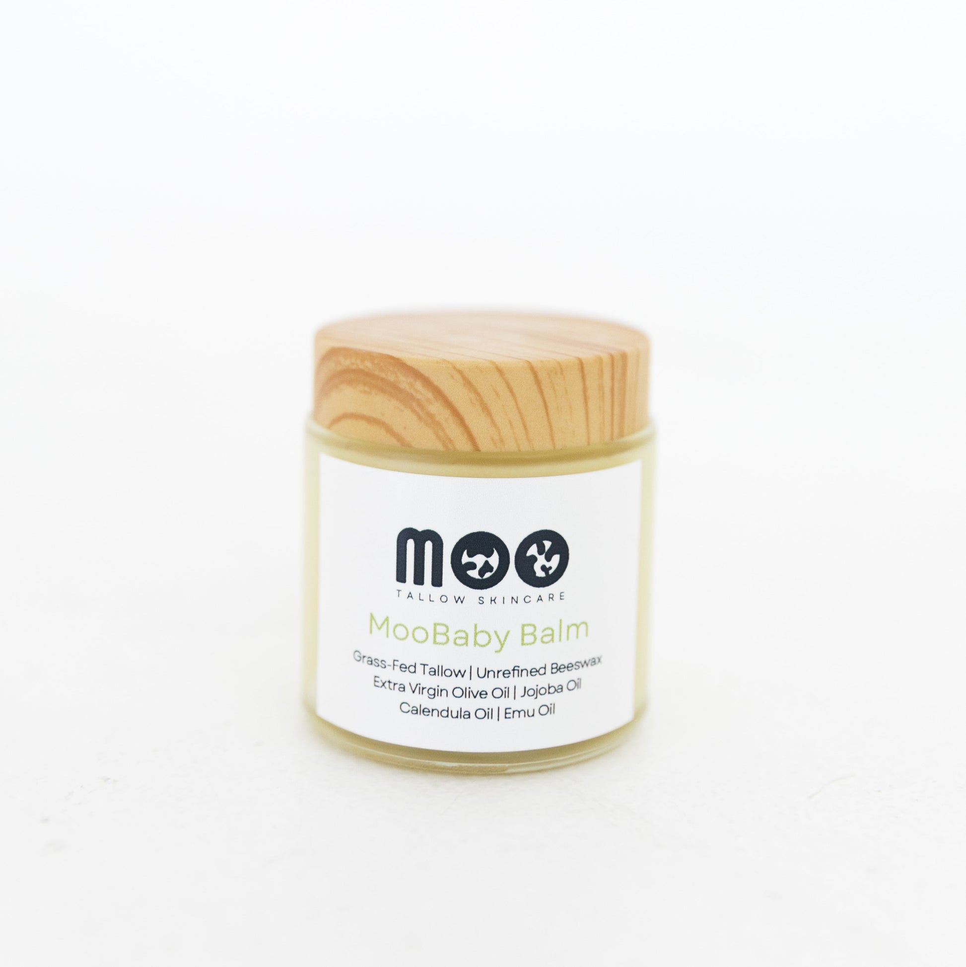 Jar of Moobaby balm with wooden lid on a white background