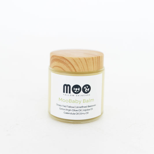 Jar of Moobaby balm with wooden lid on a white background